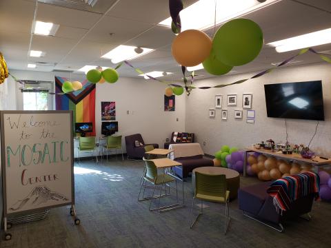 MOSAIC Center room with chairs, tables, TV, whiteboard, and colorful decorations