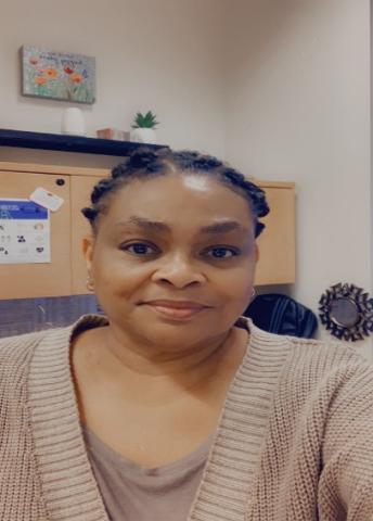 A Headshot selfie of Dee Ladson in a brown Cardigan